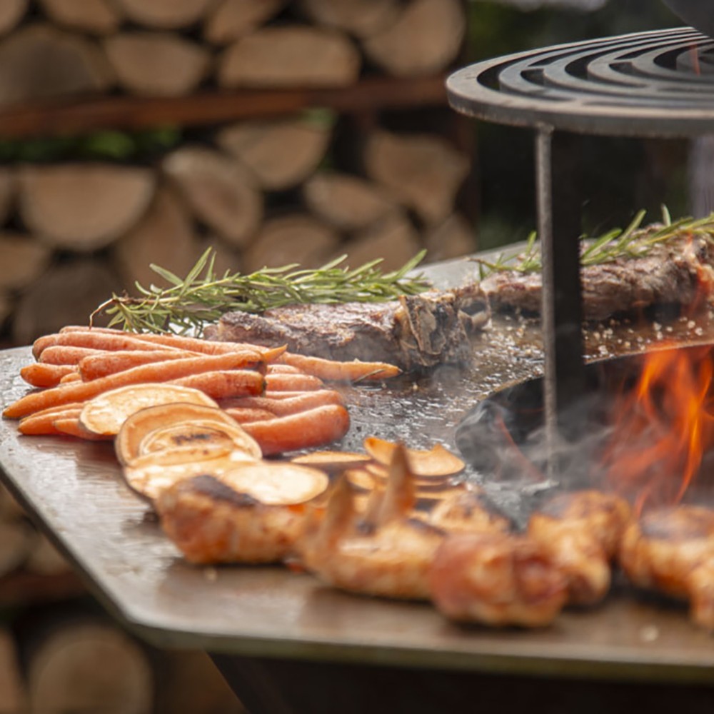 Cuisiner confortablement avec le Brasero Iwona Grill 100 (exemple d'utilisation, anneau et grille vendus séparément)