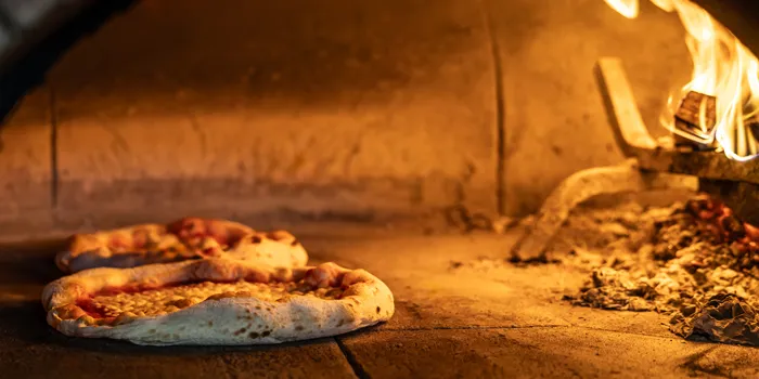 Pizzas dans un four à bois professionnel dans une pizzeria