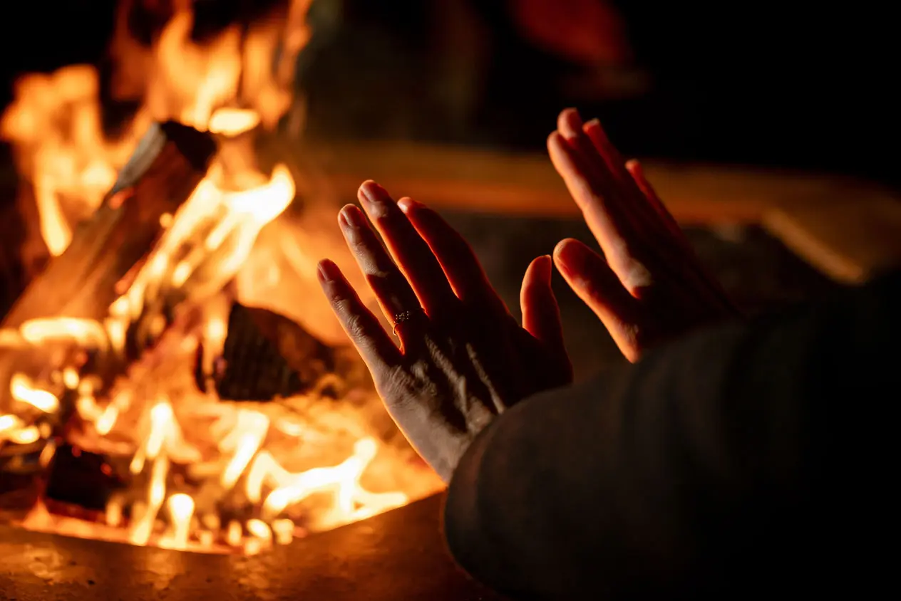 mains qui se réchauffent auprès du feu